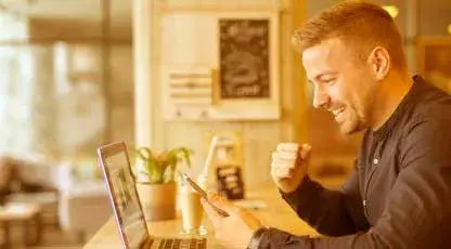 Una mujer joven escucha música y navega en su portatil con el Plan Novice Defense para trabajar